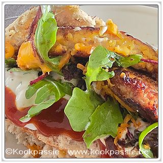 kookpassie.be - Varkens Kaasburger, sla, gebakken rode ui met balsamico, cheddar kaas, gemengde sla, tzaziki en curry tomatensaus. Broodje in airfryer verwarmd
